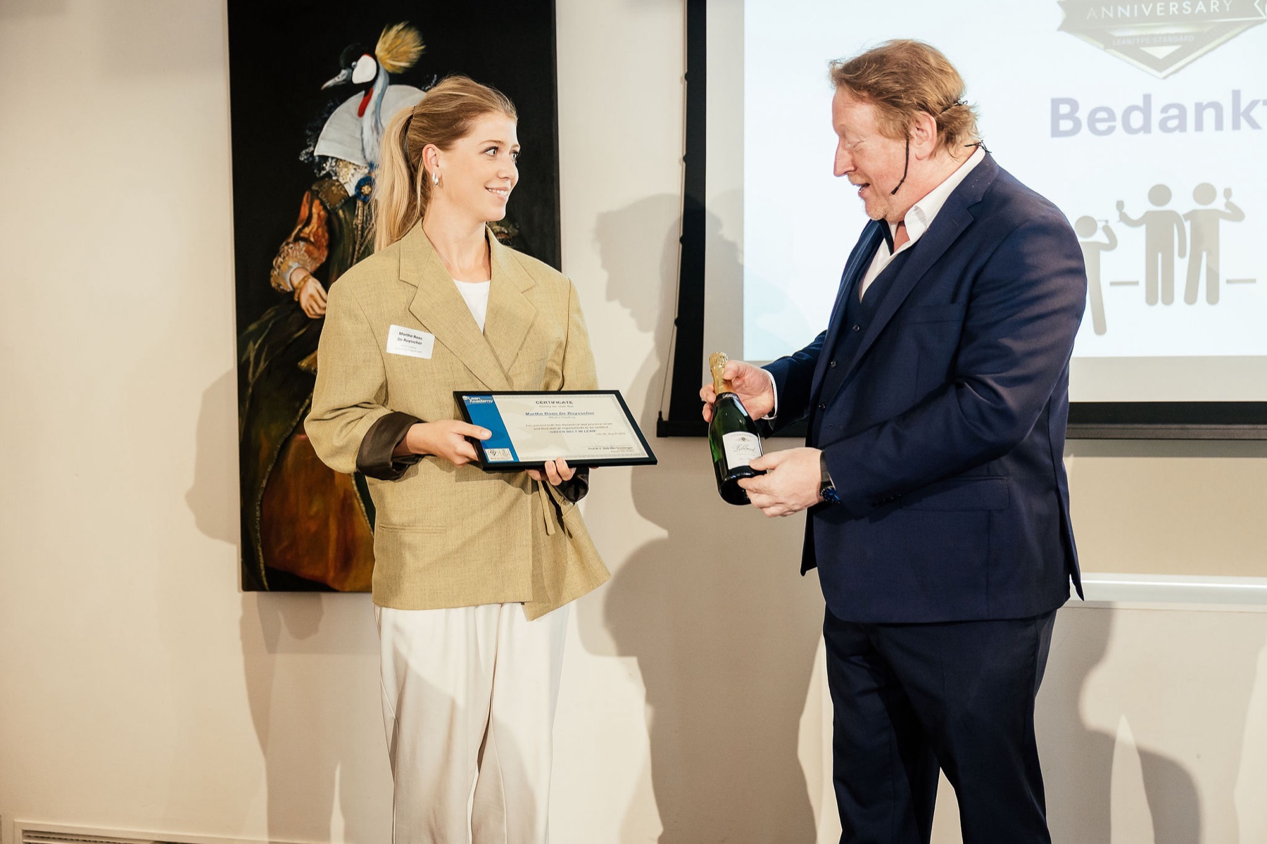 A participant receiving a certificate from Dirk Van Goubergen at Lean Academy